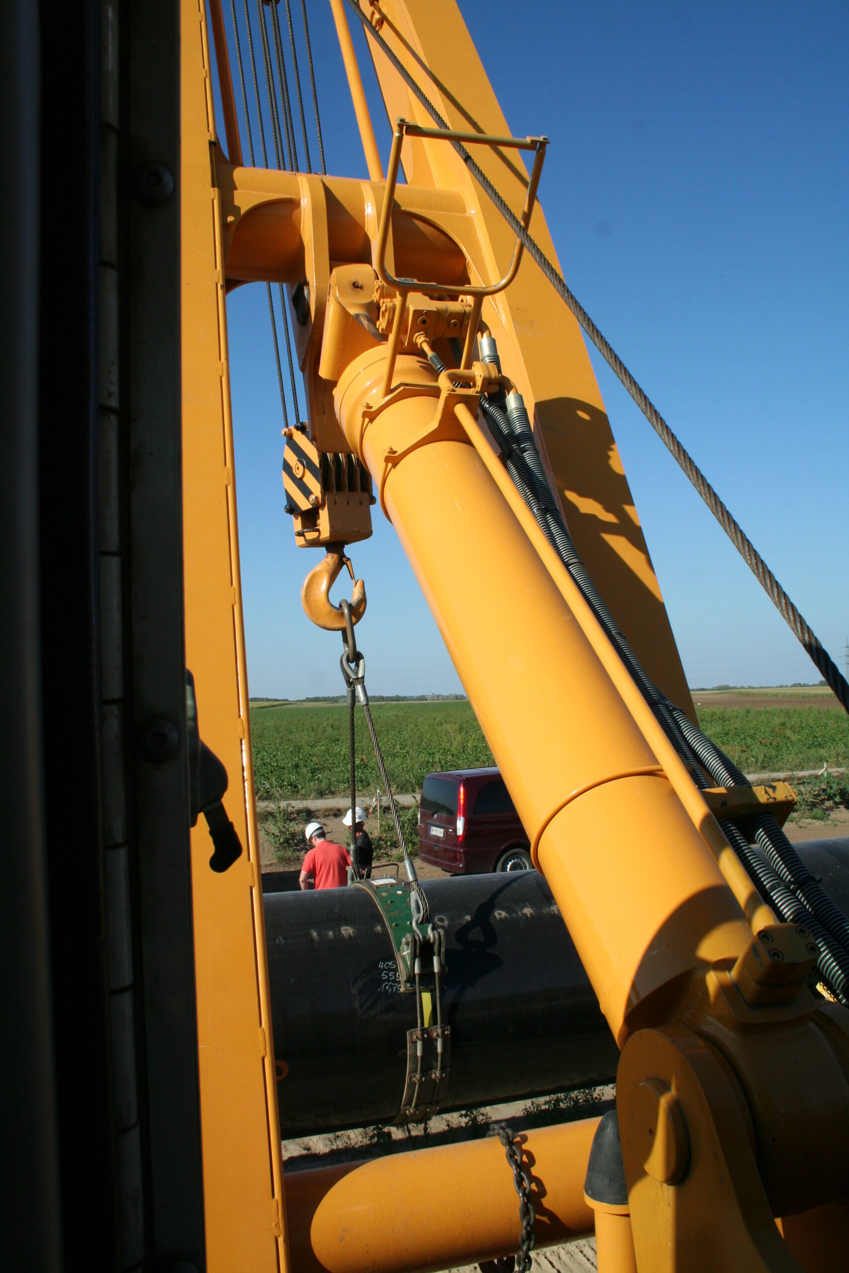 view from the closed cabin on the boom cylinder of a yellow liebherr pipelayer